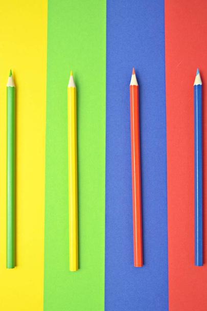 Čtyři různé barevné pastelky rozdělují oblast na čtyři úrovně, které samy mají barvu pastelky-koncept s rozdělenou plochou a barevnými tužkami  - Fotografie, Obrázek