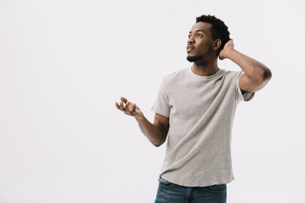 hombre afroamericano confuso gesto y tocar el cabello aislado en blanco
  - Foto, imagen