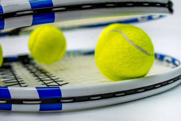 pelota de tenis y raqueta sobre fondo blanco - Foto, Imagen