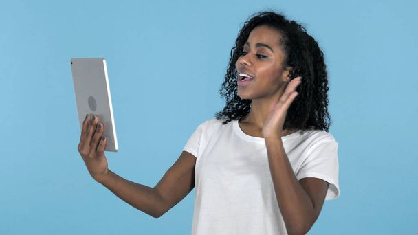 Chat video da ragazza africana tramite tablet isolato su sfondo blu
 - Foto, immagini