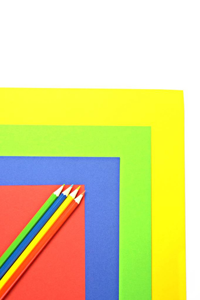 Quattro diversi pastelli colorati dividono un'area in quattro livelli, che a loro volta hanno il colore dei pastelli - un concetto con superficie divisa e matite colorate
  - Foto, immagini
