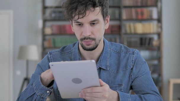 Casual jeune homme naviguant sur Internet sur tablette
 - Photo, image