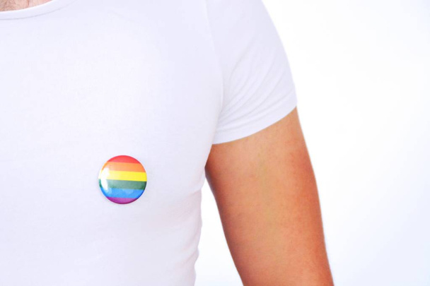ein Mann Mitte Zwanzig trägt einen Knopf mit dem Symbol für Transgender auf seiner Anzugjacke - Konzept für Akzeptanz und Toleranz im Arbeitsleben - Foto, Bild
