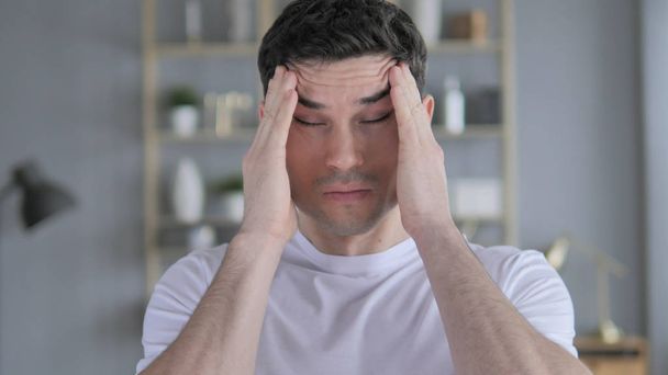 Kopfschmerzen, Porträt eines angespannten jungen Mannes mit Kopfschmerzen - Foto, Bild