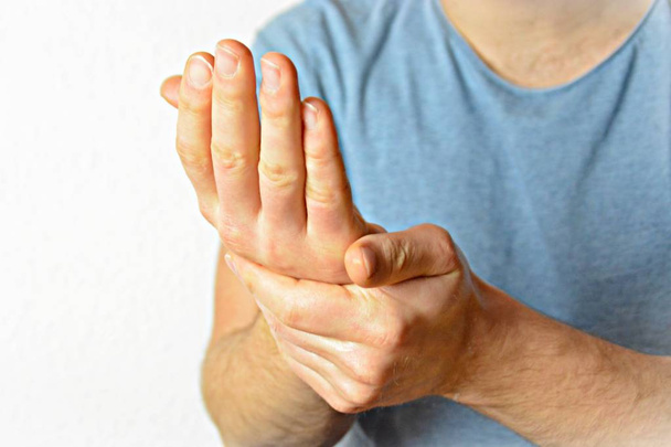A young man puts his palms together - a gesture that has different meanings in different countries, with the focus on the man's hands  - Photo, Image