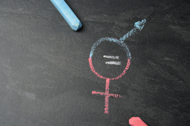 On a dark marble surface, the symbol for man and woman was recorded with different chalks and an actual match between them - concept for the equality of men and women - Photo, Image