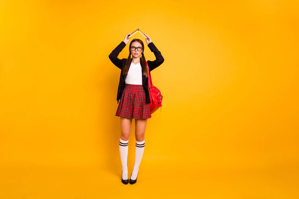 Full length body size view of her she nice attractive bored girl holding in hands book over head like roof boring classes courses pass exam test isolated over bright vivid shine yellow background - Zdjęcie, obraz
