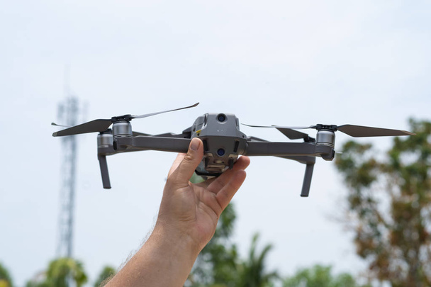 Vrouwelijke hand lanceert drone voor vlucht, waarmee je Foto's en video-opnames maken, close-up - Foto, afbeelding