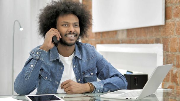 Negociación de un hombre africano hablando por teléfono en Loft Office
 - Foto, imagen