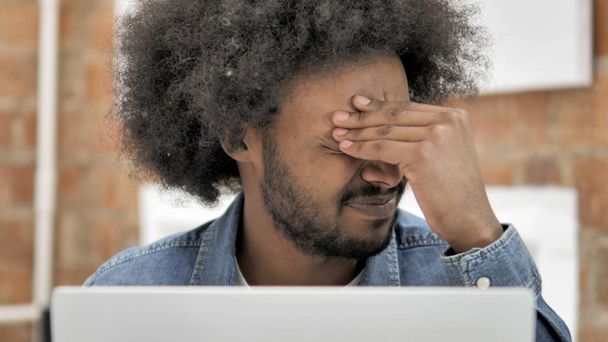 Zbliżenie afrykańskiego mężczyzny z bólem głowy w pracy - Zdjęcie, obraz