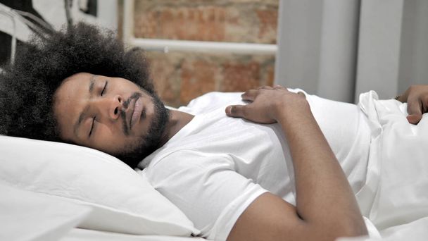 アフリカ人男性がベッドで寝る - 写真・画像
