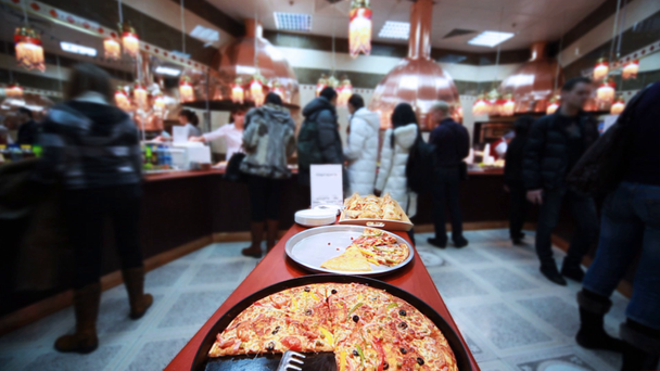 smaczne włoskie pizza w kawiarni gdzie sprzedaje dużo dobrego jedzenia - Materiał filmowy, wideo