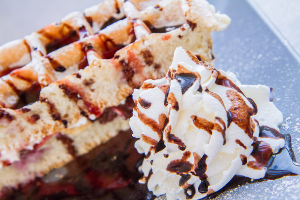 Waffles with whipped cream, cherries and chocolate sauce - Foto, Bild