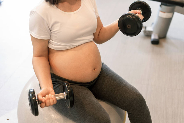 Active pregnant woman exercise in fitness center. - Photo, image