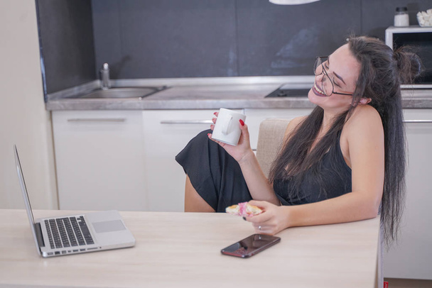 evde yalnız bir dizüstü bilgisayar ile masada oturan gözlük ile sevimli kız - Fotoğraf, Görsel