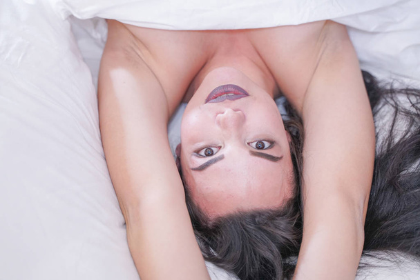 affascinante giovane ragazza bruna a riposo nel suo letto bianco
 - Foto, immagini