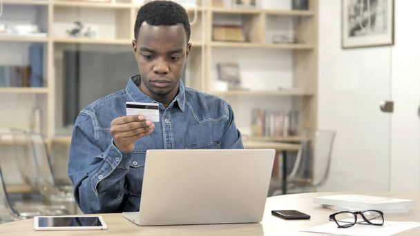 Online Shopping by Young African Man, Paying Online - 写真・画像
