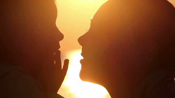 Silhouettes of mother and daughter heads, girl close face by palms - Filmagem, Vídeo