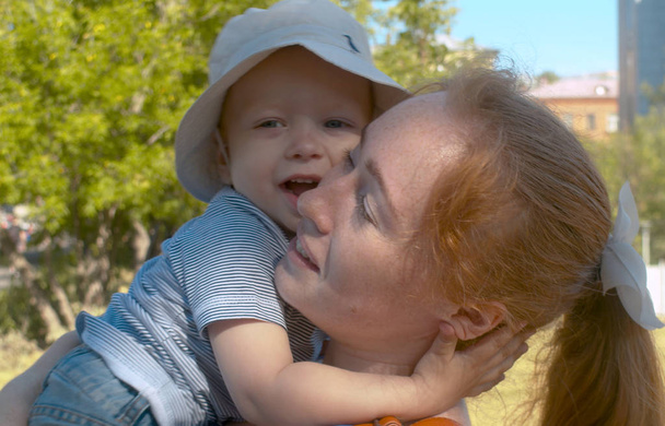 pequeño lindo hijo abrazando su atractivo mamá
 - Foto, Imagen
