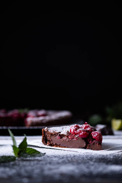 Chocolate clafouti with cherries on a wooden table. French delicious dessert. - Photo, Image