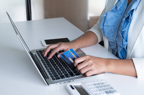mujer utilizar la tarjeta de crédito para las compras en línea en su ordenador portátil y teléfono
 - Foto, Imagen