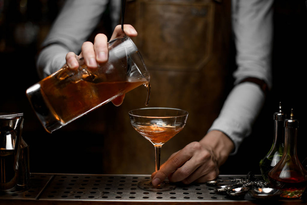 Bartender pouring an alcohol cocktail with strainer - 写真・画像