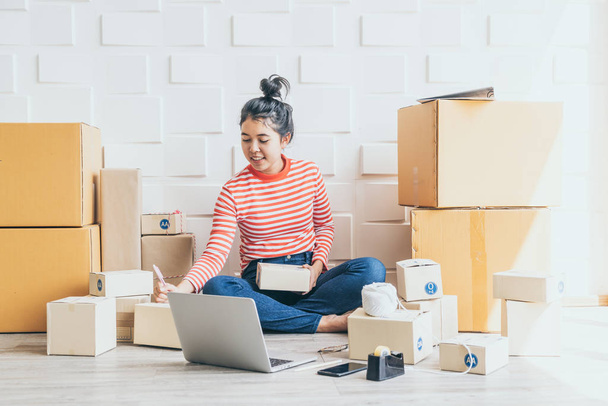 Asian Women business owner working at home with packing box on w - Photo, image