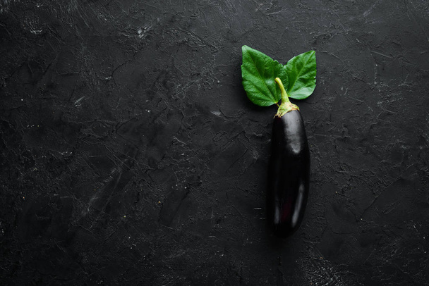 Fresh eggplant on black background. Vegetables. Top view. Free copy space. - Foto, afbeelding