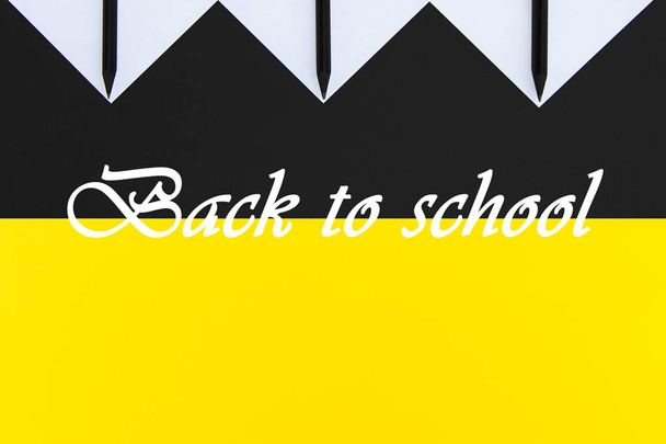 White stickers with black pencils lined with a geometric pattern on a background of yellow and black.  - Photo, Image