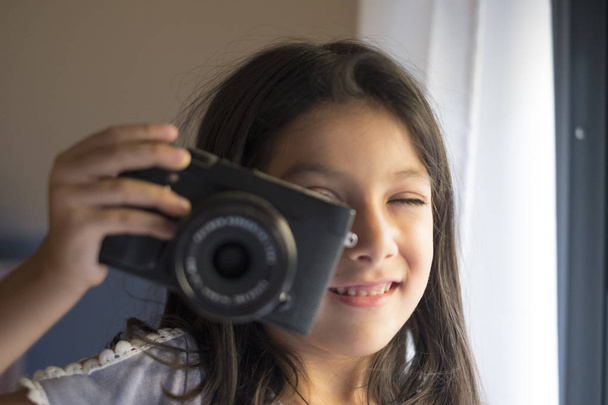little girl taking picture with mirrorless camera - Foto, afbeelding