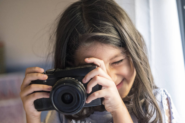 little girl taking picture with mirrorless camera - Foto, imagen