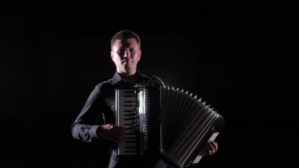 jeune accordéoniste joue magistralement l'accordéon en studio sur fond noir, isolé
 - Séquence, vidéo