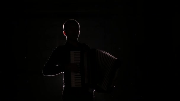 jeune accordéoniste joue magistralement l'accordéon en studio sur fond noir, isolé
 - Séquence, vidéo