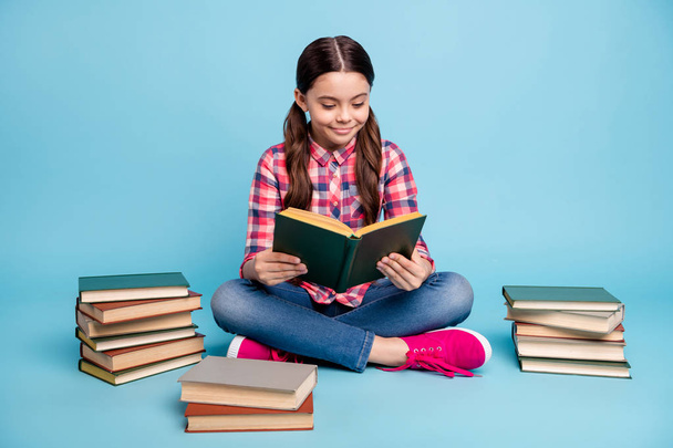 Portrait of nice attractive lovely focused cheerful girl wearing checked shirt sitting in lotus pose library academic house home reading isolated over bright vivid shine blue turquoise background - Photo, image