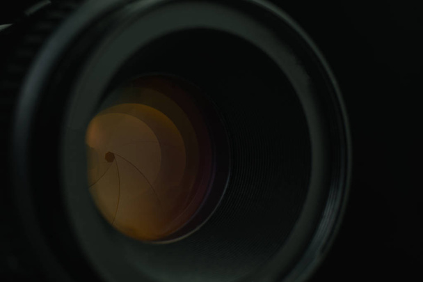 Cerrar lente de apertura de la cámara con reflejo de vidrio amarillo. Vista macro
. - Foto, imagen