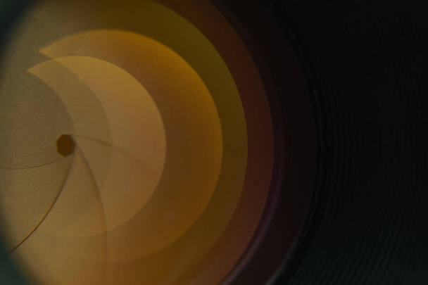 Close-up camera diafragma lens met geel glas reflectie. Macro weergave. - Foto, afbeelding