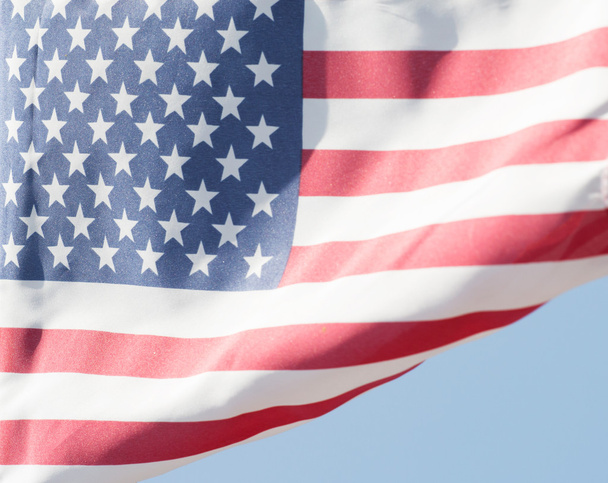 太陽に照らされたアメリカの国旗が風に - 写真・画像