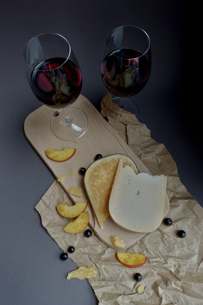 delicious composition of wine and cheese on a dark background - Photo, Image