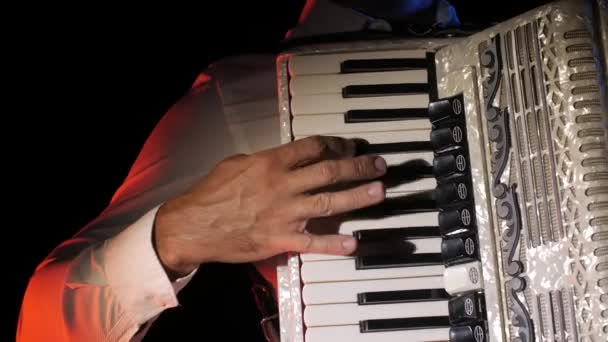 adam müzisyen ustaca siyah bir arka planda stüdyoda akordeon oynar, el ve anahtarlar yakın çekim, izole - Video, Çekim