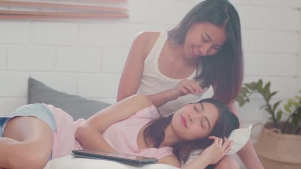 Asijské Lesbičky LGBTQ ženy pár Polibky a objetí na posteli doma. Mladá Asie milovnice šťastné relaxace odpočívejte pohromadě romantickou dobu po probuzení v ložnici doma v dopolední koncepci. - Záběry, video