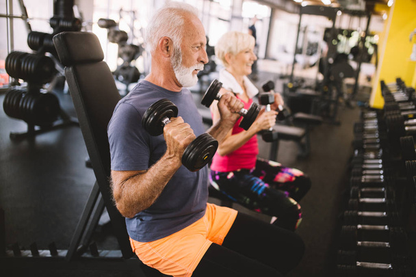 Hombre y mujer maduros en forma haciendo ejercicios en el gimnasio para mantenerse saludables
 - Foto, Imagen