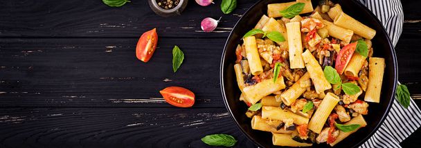 Rigatoni pasta with chicken meat, eggplant in tomato sauce in bowl. Italian cuisine. Top view. Banner - Foto, Imagem