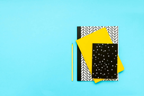 Back to school concept. School supplies: notebooks and pens on blue background. Top view. Copy space. Flat lay - Fotó, kép