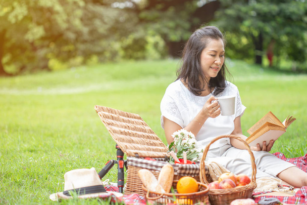 asijské ženy čtou knihu a piknik na zahradě. - Fotografie, Obrázek