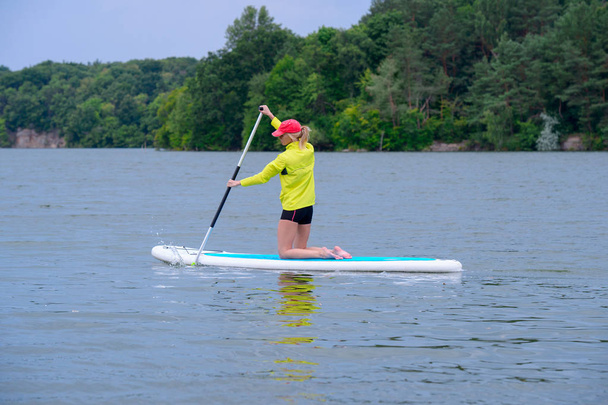 Happy woman resting on the SUP board and enjoying life in the ea - Photo, Image