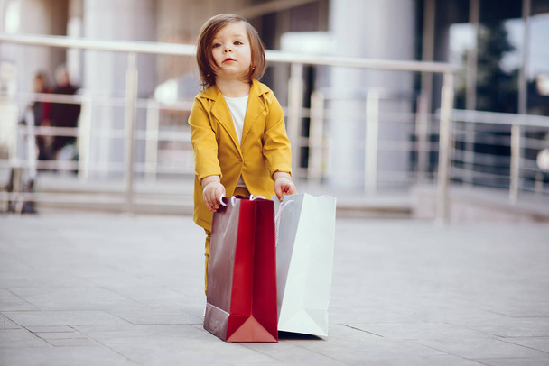 Petite fille mignonne avec sac à provisions dans une ville
 - Photo, image