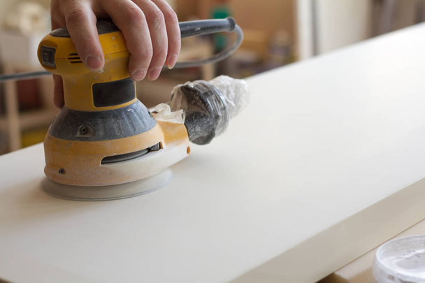 Carpenter Szlifowanie powierzchni elewacji przed montażem mebli na warsztat stolarski niewyraźne tło, selektywne skupienie - Zdjęcie, obraz