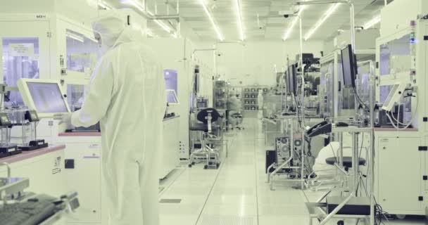 Werknemers in een schone ruimte in een productiefaciliteit voor halfgeleiders - Video