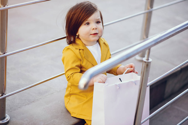 Cute little girl with shopping bag in a city - Photo, image