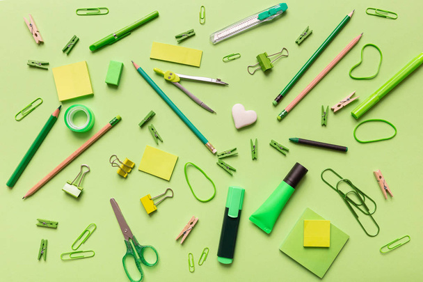 Flache Bürofläche, Schulschreibwaren auf grünem Hintergrund - Foto, Bild